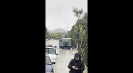 Bus floating down street - Auckland Floods, Sunnynook Road