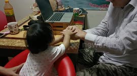 A six month old baby gets great fun playing with a wooden golden egg.