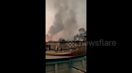 Residents evacuate by boat after wildfire breaks out in Punta Lavapie Cove in Biobío, Chile