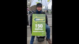 A man hanging a Subway billboard at Westminster Bridge, London, UK