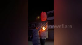 Candle wick drops onto girl's face when she tries to fly sky lantern