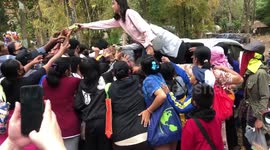 Frenzied locals swarm Good Samaritans giving away free food outside temple
