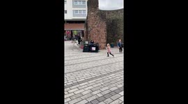 A boy is doing some very impressive busking on a piano when a little girl decides to dance to his music