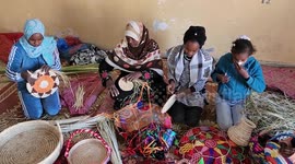 Palestinian Um Mansour Falah, with her children, and grandchildren, make souvenirs from palm leaves at their home