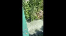 My friend and I bungee jumping above a lake, surrounded by mountains in Whistler, BC Canada