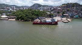 An off-shore support vessel is moored in a small port in the city of Vitória