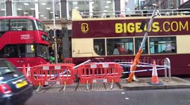 Crash scene on Kensington High Street cordoned off with traffic lights bent and flower tribute