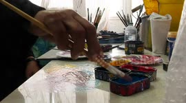 Palestinian artist Shafiq Radwan, 82, paints at his home in Jabalia refugee camp, in the northern Gaza Strip.