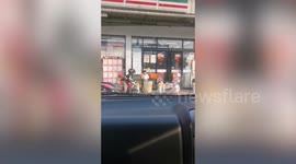 Kind little schoolboy feeds stray dogs outside convenience store in Thailand