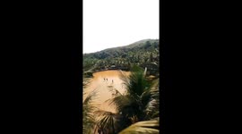 Impressive footage shows man surfing across watery field being pulled. by bulls