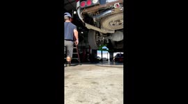 Smart mechanic channels his inner horse to kick stuck wheel off the vehicle