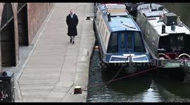 Strolling along the Regents Canal, past many canal boats, London, United Kingdom