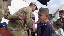 Soldiers hand out caps to children in earthquake-affected areas in Turkey