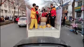 Driver honks his horn to harmonize with a gong and drum team on the street in China