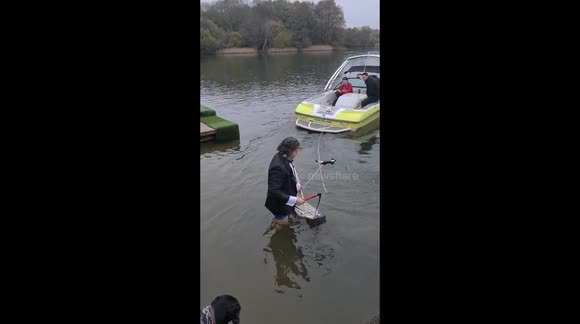 Daredevil surfs across UK lake on ironing board