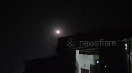A time lapse of the full moon over the roof of a house outdoors in cloudy weather in India