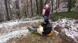 Sledding fail. Snow fail. Crashing into fire pit with cute puppy in arms. Funny and scary.