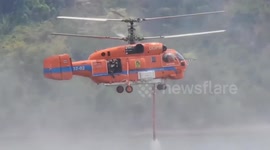 Helicopter dumps water on forest fires in Thailand