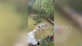 Helpful boy scout bends forwards on bridge to let friends pass first
