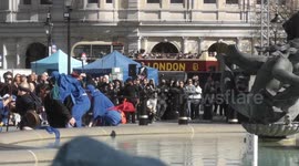 An actor goes splashing into the water fountains at Trafalgar Square during a performance of The Passion Of Jesus play held on Good Friday