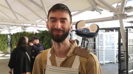A man with a droid on his shoulder at the Star Wars Celebration held at the Excel Center in London