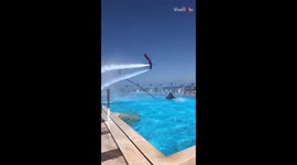 Guy in a Superman suit flyboarding over a pool at Pickalbatros Sea World resort, Egypt