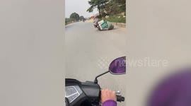 Wonky motorcycle drags washing machine along road in Vietnam
