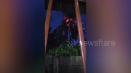 Sparks fly from coconut tree struck by lightning during storm in Thailand