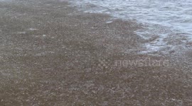 Melting pancake ice creates satisfying noise as it washes up on Wisconsin coast