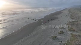 Ocean coast rescue operation to pull car stuck in ocean shortly before high tide and sunset