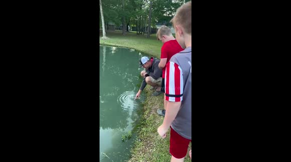 Watch this kid catch fish size of his arm using just his bare hands ...
