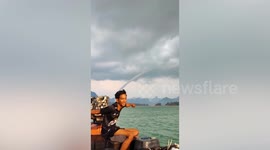 Waterspout tornado towers above hills in southern Thailand