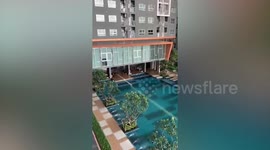 Strong wind blows table and chairs into swimming pool during storm in Thailand