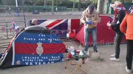 One of the people camping out to see the Royal Coronation tries to make toast in a very slow way