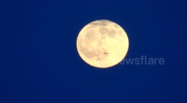A Plane goes infront of the flower full moon in St Petesrburg, Russia
