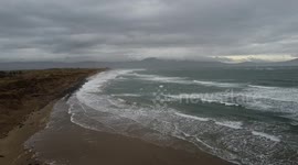 Drone shot of a dramatic stormy sea with welsh mountains in the background
