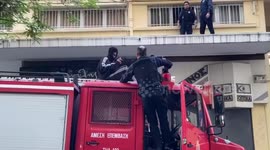 Graffitiing youths leap across rooftops to escape Greek police officers in pursuit