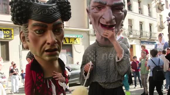 Dancers on stilts wearing giant heads parade down streets of Madrid