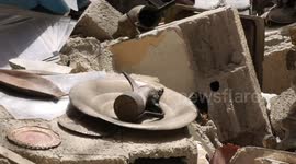 Palestinian man Hazem Muhanna, 62, inspects the antiquities under the rubble of his house, which was destroyed in an Israeli airstrike in Gaza city.