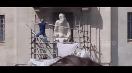 Controversial statue outside BBC attacked by masked protester