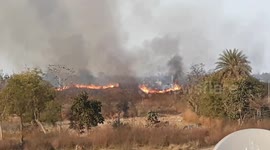 A forest fire near a village in India has left the sky smoky with smoke billowing from the fire