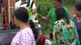 Local villagers do some shopping for kitchen knives and slash hooks from a local vendor who sells from his fully loaded pickup truck.