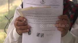 Palestinian citizen, Saqr Abu Ayyash, holds identification papers for his lands in Beit Ummar, north of the West bank city Hebron