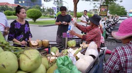 Vendor sells fresh coconut water by roadside in Phnom Penh, Cambodia