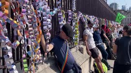 Activists chain themselves with paper chains to the fence of the Houses of Parliament fence during the Not My Bill protest in London