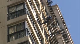 Specialist gets rid of the ice pillar outside the 17-floor building in minus 12 degree