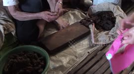 old lady rolls, sells  and smokes  her own cigars.