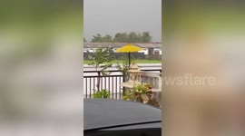 Yellow umbrella amusingly 'refuses' to be carried away by wind during storm