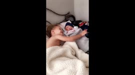 Big sister meeting baby brother and giving him a kiss, but getting thrown up on!