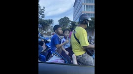 Siblings Share Treat on Back of Motorbike